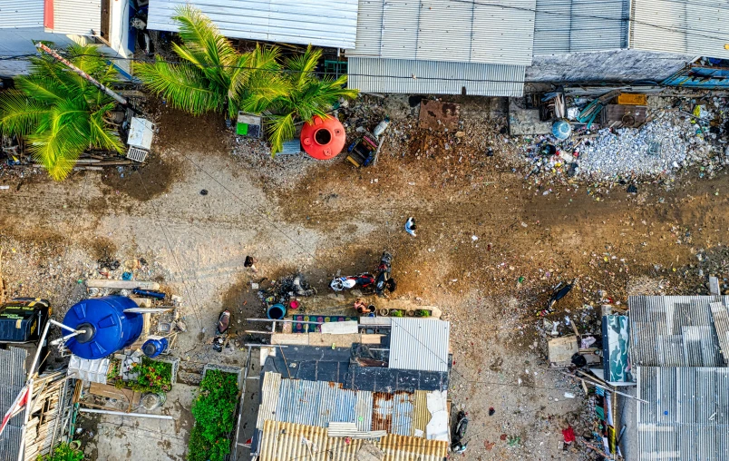 an overhead view shows lots of houses in the background and dirt everywhere, looking down at them