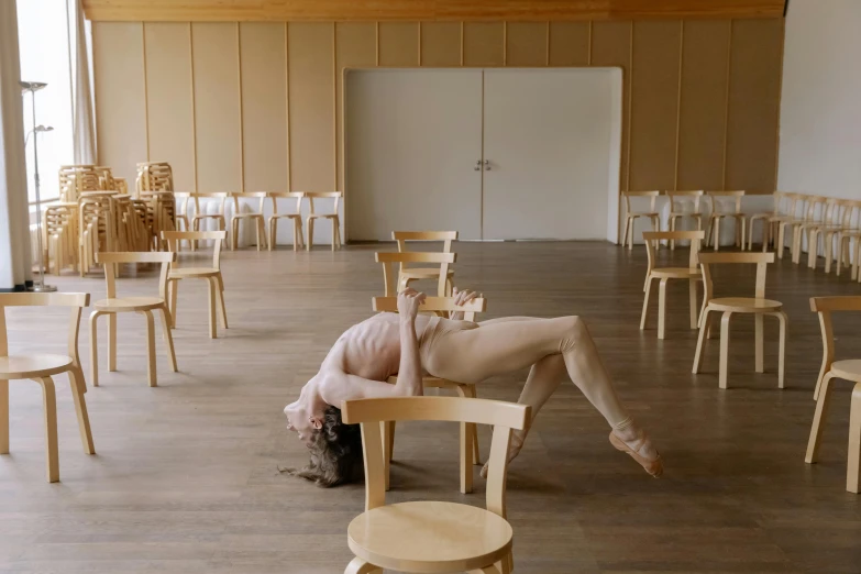 a girl is sitting in a chair in an empty room