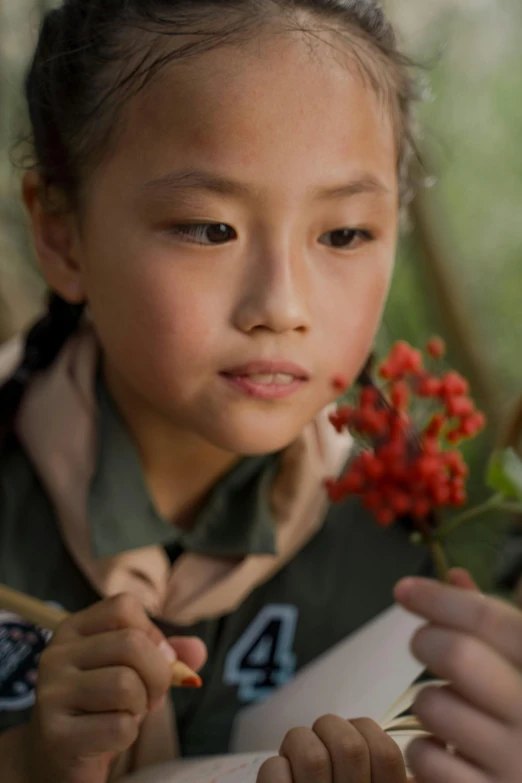 the young child is holding a stick with flowers in it