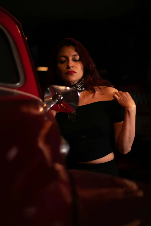 a woman leans against the side of a car