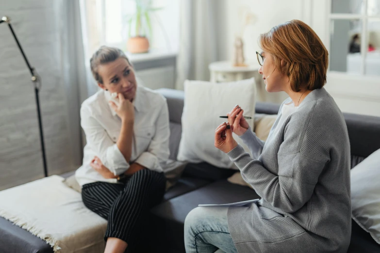 an elderly couple are sitting on a couch and talking