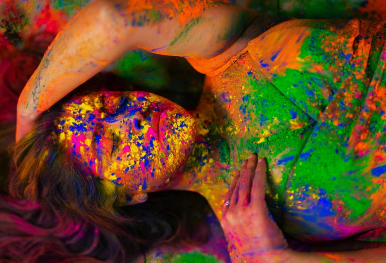 a woman covered in colorful powder posing