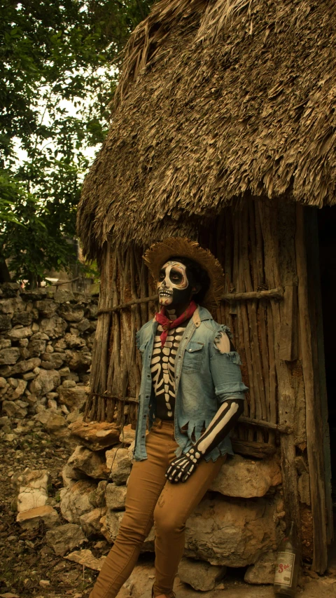 a skeleton that is standing up in front of a hut