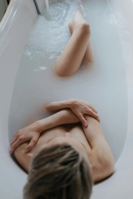 a woman is sitting in the tub in the room