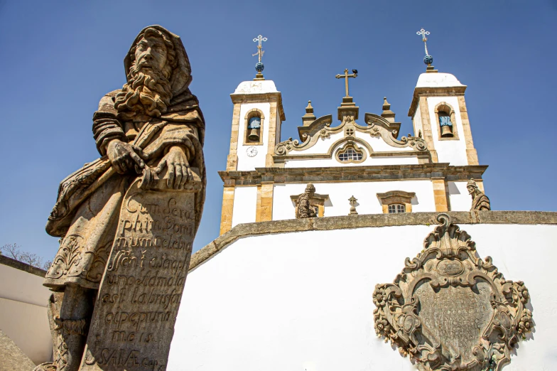 a statue of a man with a sword near an ornate church