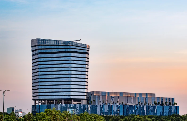 this is a tall building with some trees below it