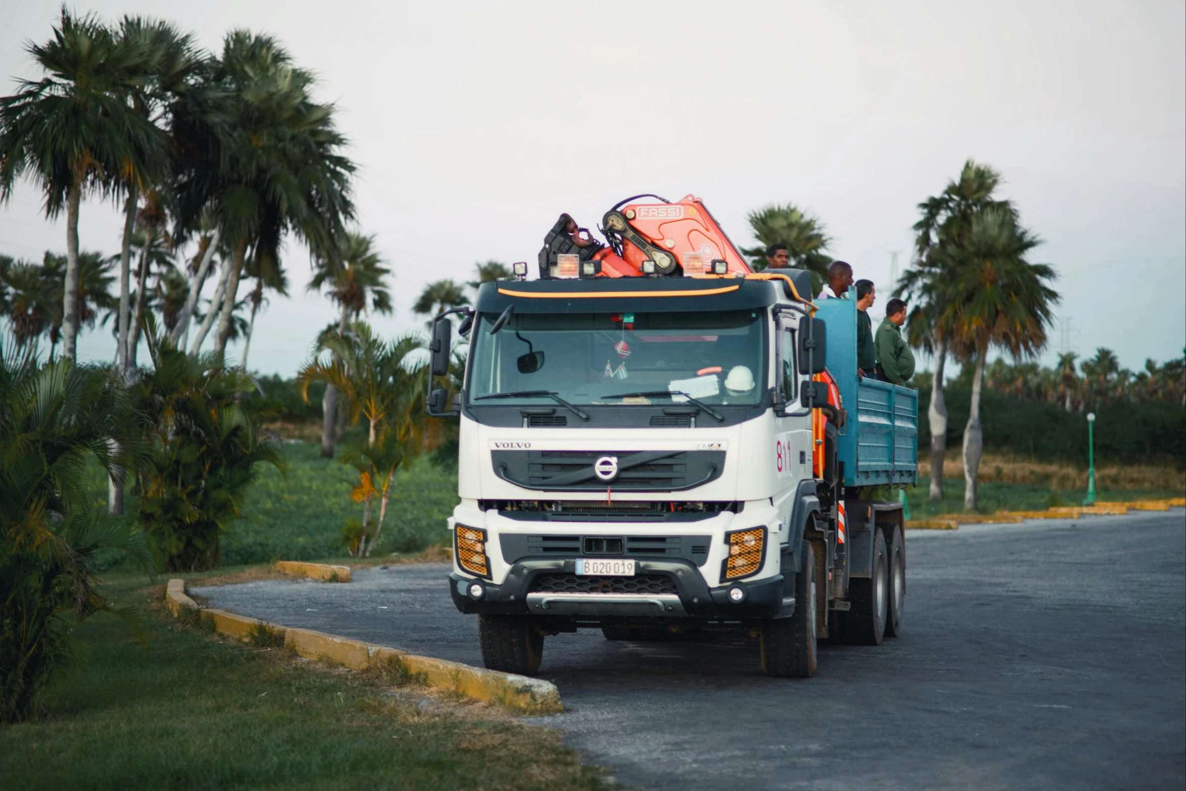 some people and trucks are parked along side a road