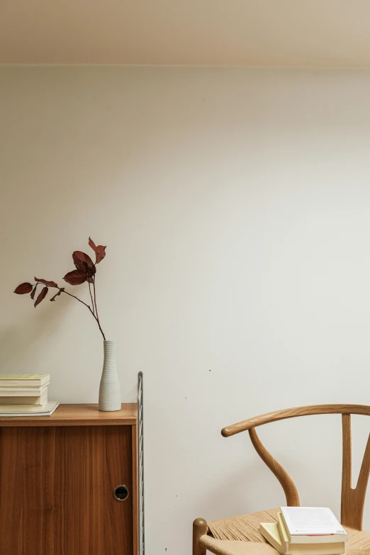 a wooden cabinet holding a vase with a plant inside of it