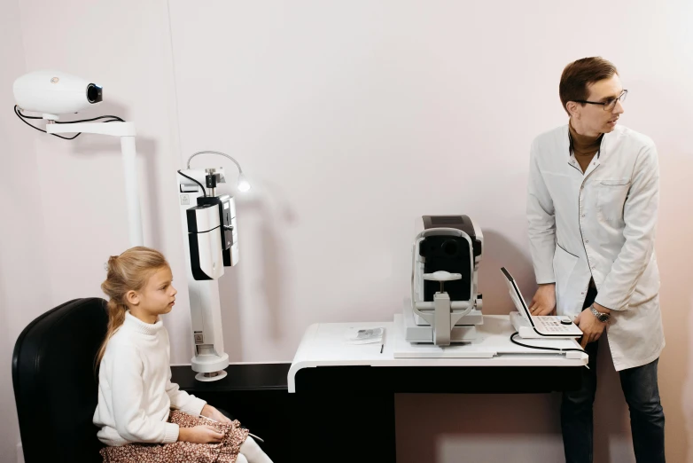 the woman is showing her little girl how to use a laptop