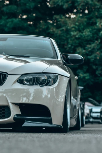 a white bmw car is parked on a road