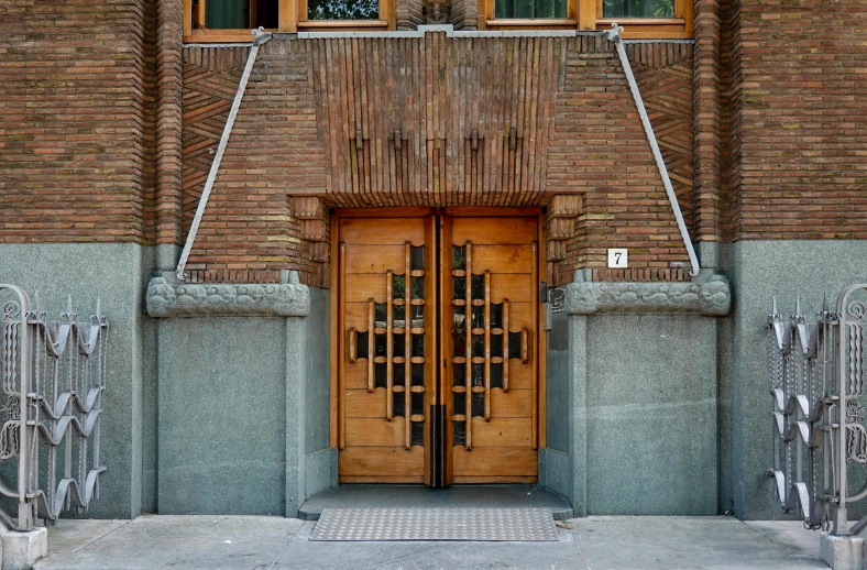 a wooden entrance door on top of a brown brick building