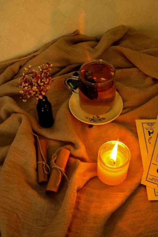 two books and a candle sit on a bed