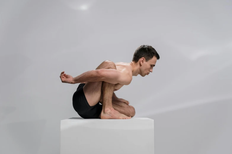 a man is doing a yoga pose on a square