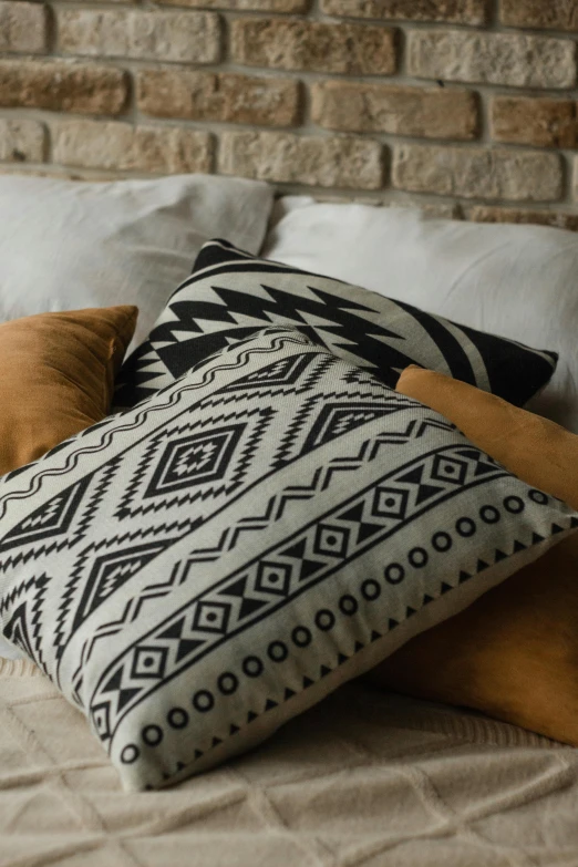 pillows with a brick wall behind them on a bed