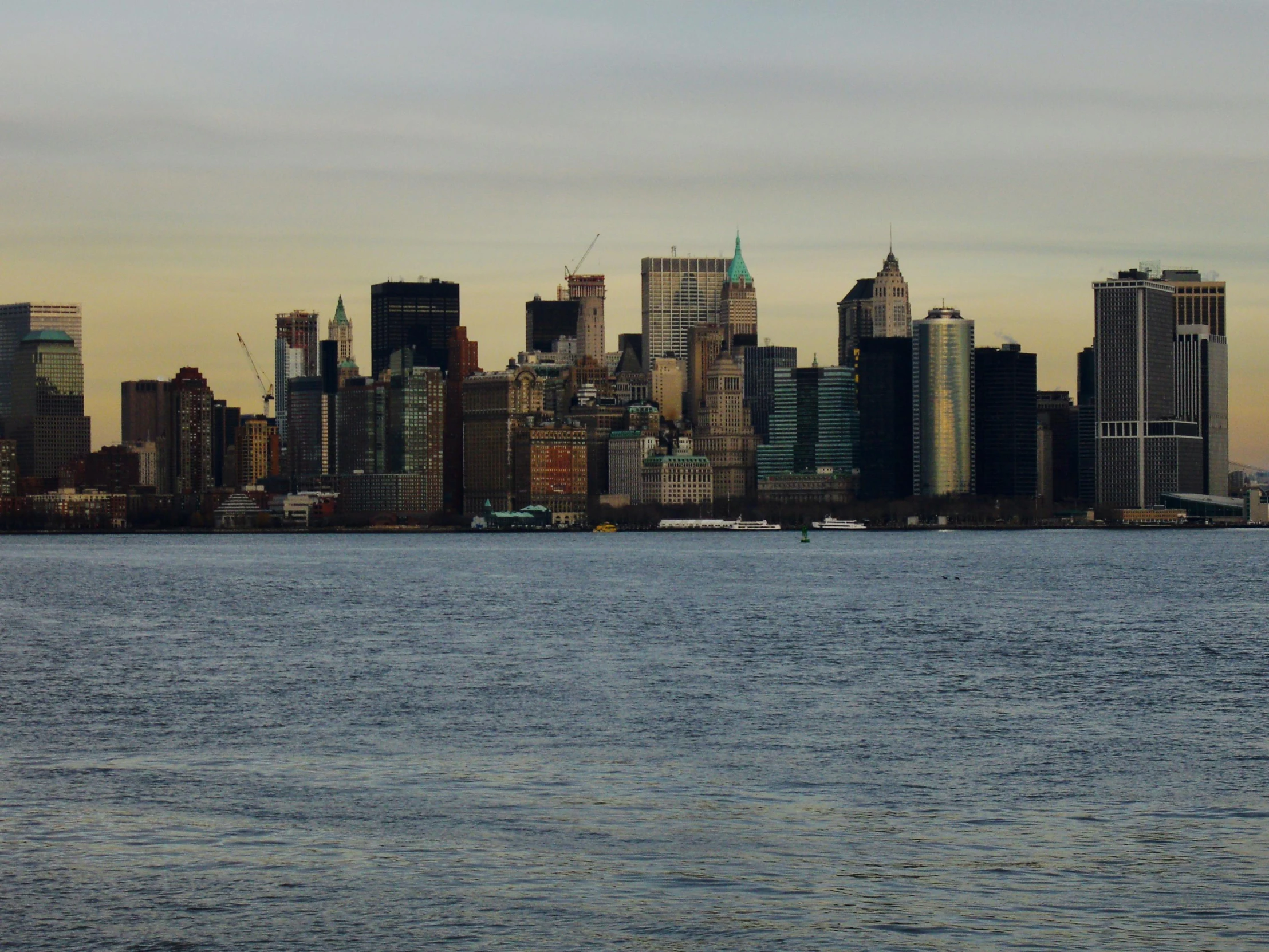 a boat sits in the water behind a city skyline