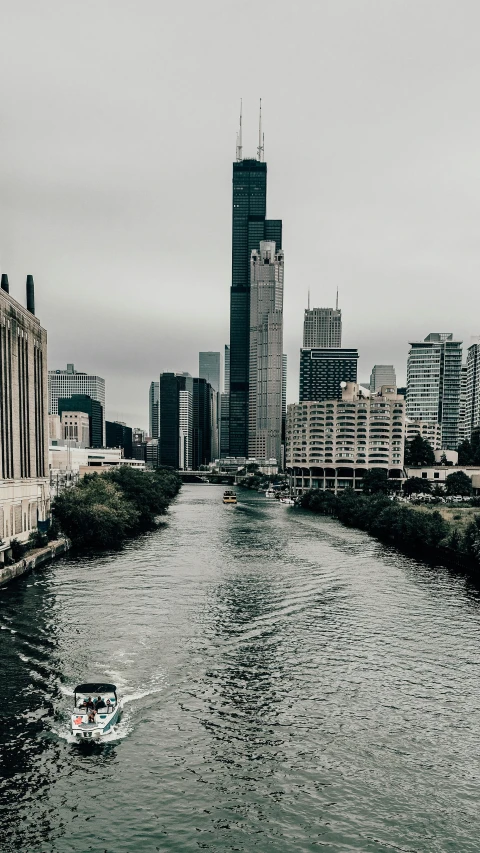 a boat going through the middle of a river next to tall buildings