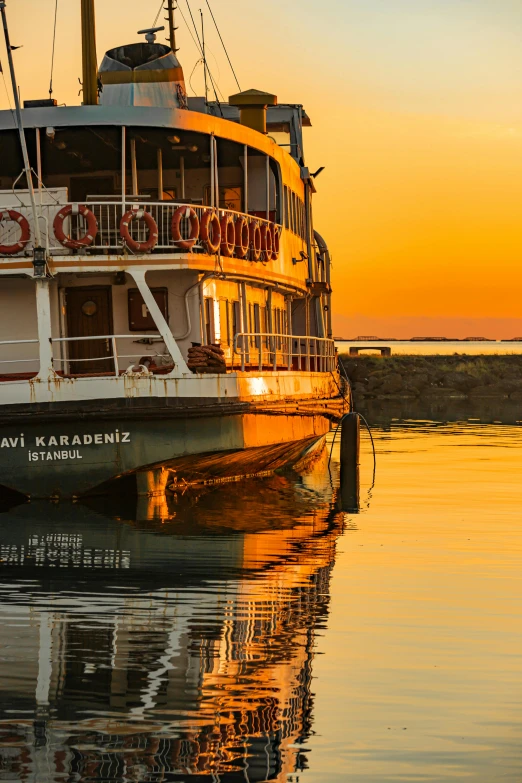 the sun rises over a large ferryboat docked