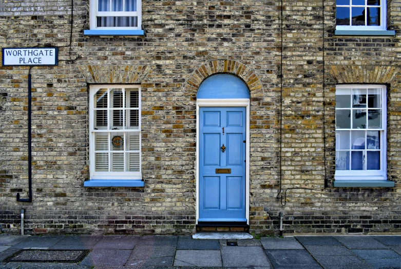 two windows are open above a blue door