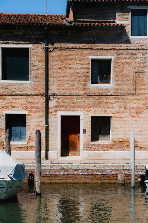 a building next to the water with a boat docked by it