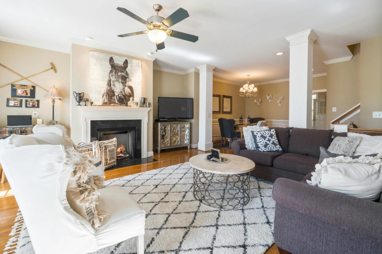 a living room with couches, chairs, a television and fireplace