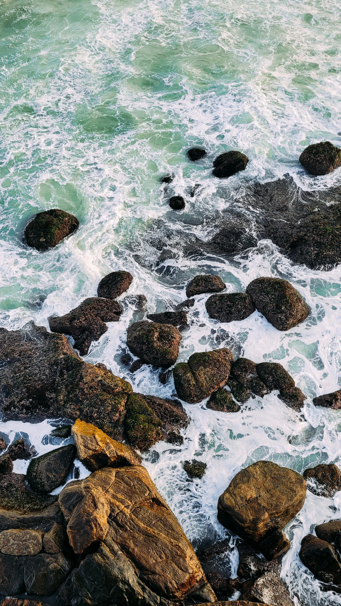 a surf board is near the rocks and the ocean