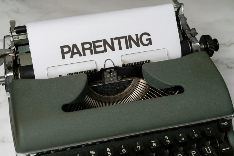 the words parenting written on a piece of paper above an old style typewriter