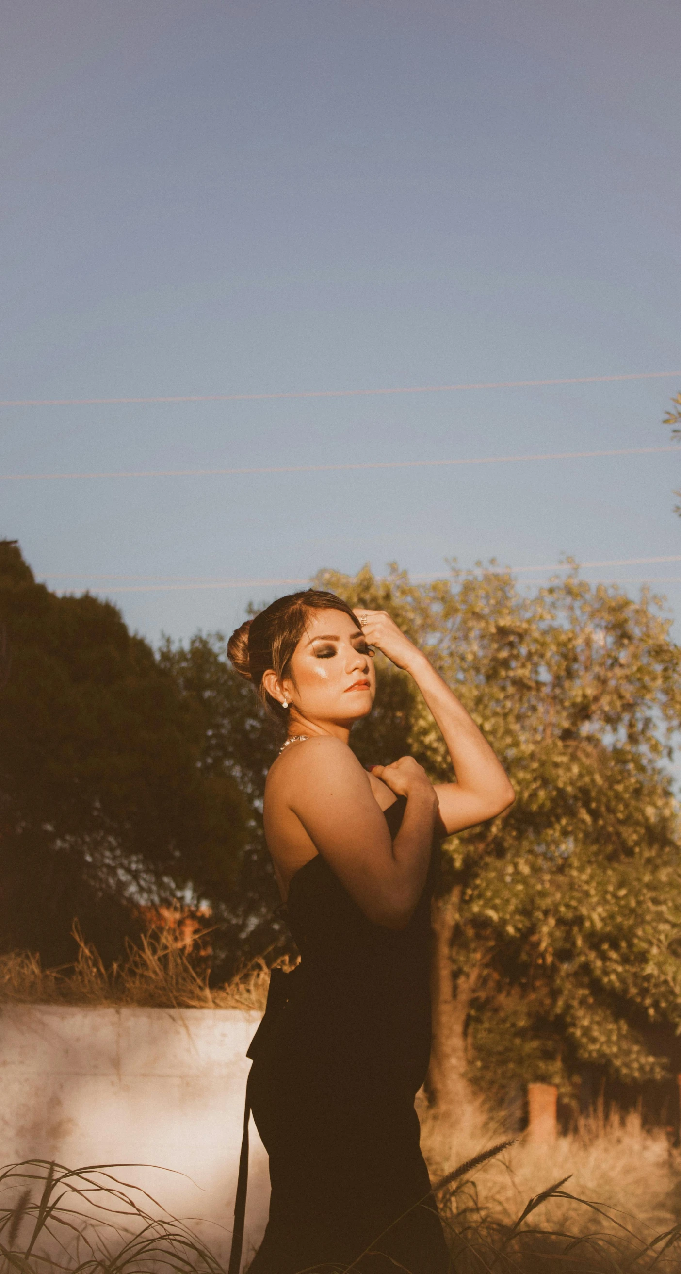 woman in black dress and headpiece posing in outdoors