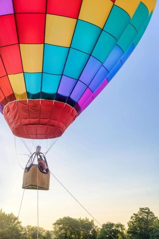 colorful air balloon with a person inside flying above it