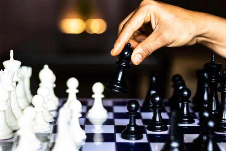 someone moving chess pieces on a chessboard