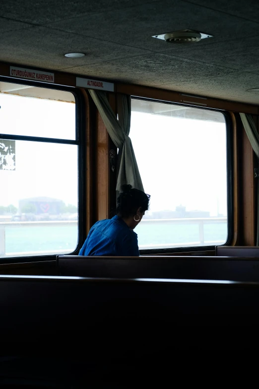 the lady is looking out of the passenger car window