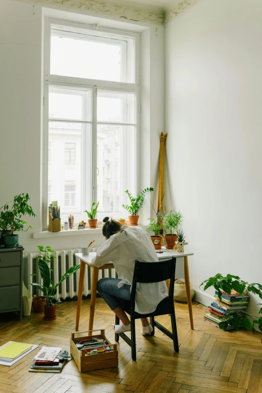 a woman is sleeping on a chair near plants