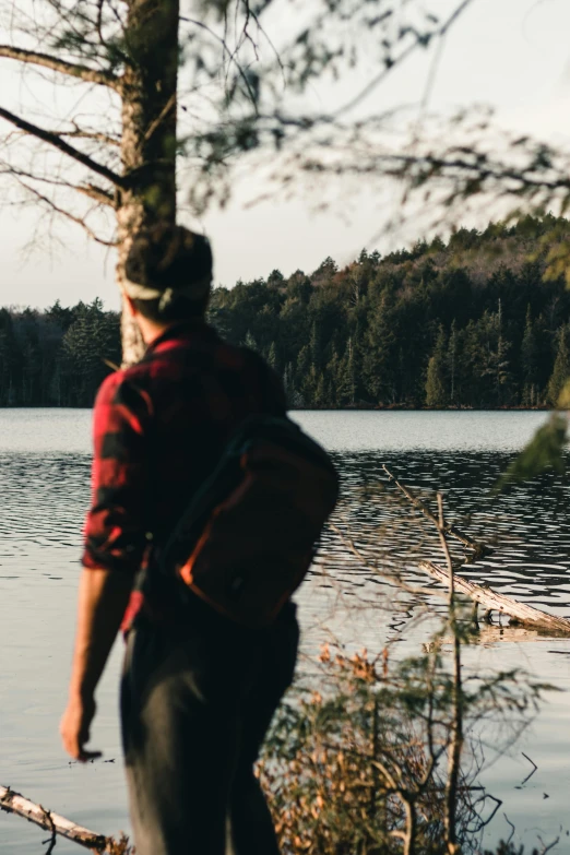 a man is standing by a small body of water