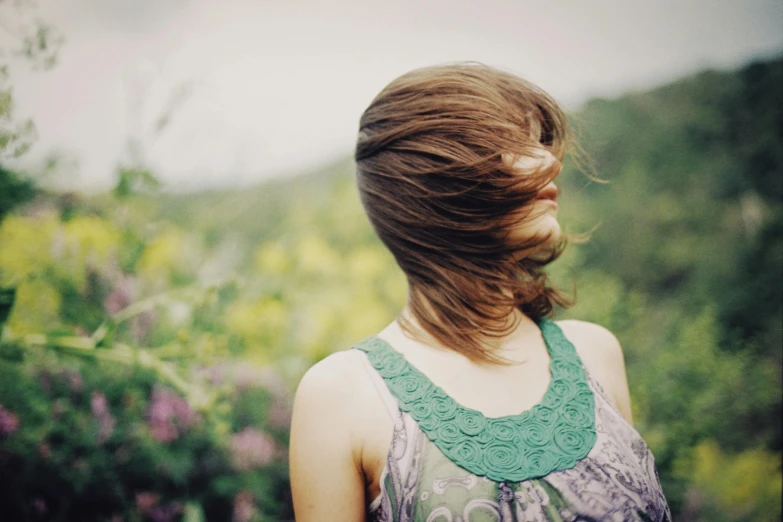 a woman standing on a lush green hillside