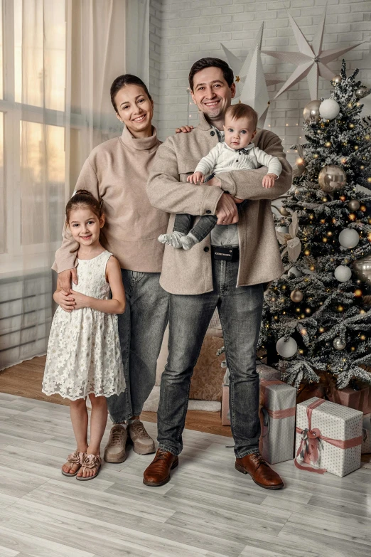 the family is posing in front of their christmas tree