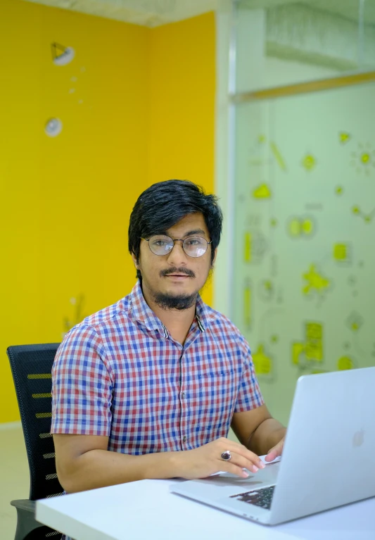 a man with glasses on a laptop