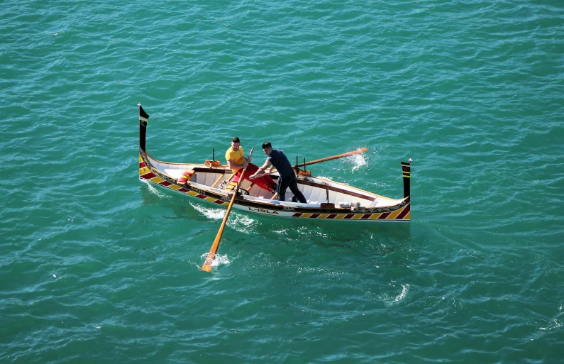 a man and woman in a boat rowing on the water