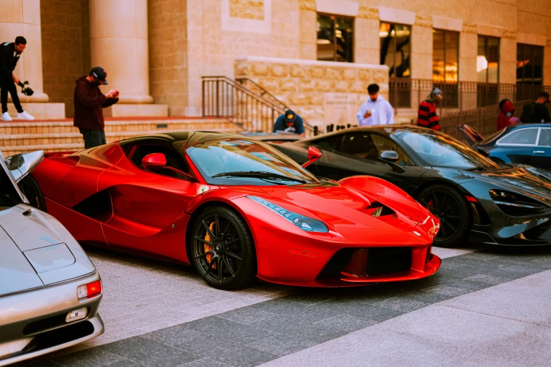 three very sleek cars parked on the side of a road