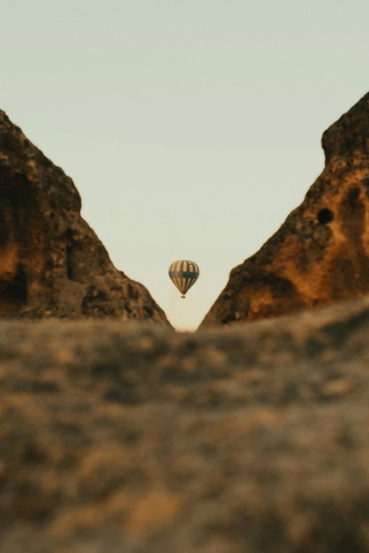 view of the ground and mountains with a  air balloon in the sky