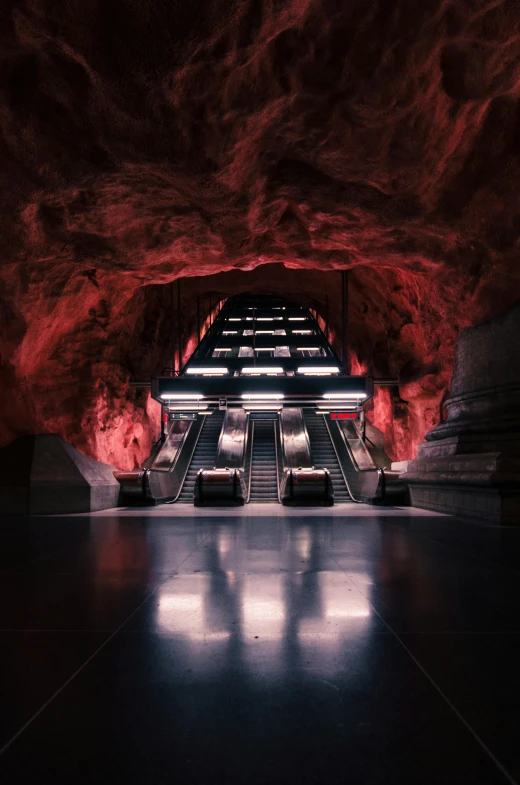 a red and black tunnel has an escalator and seats in it