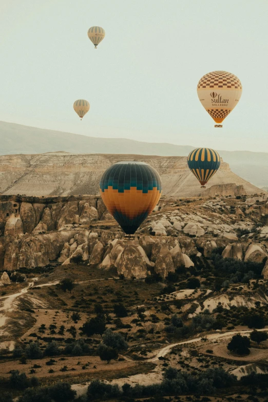 several  air balloons flying in the air above a mountain range