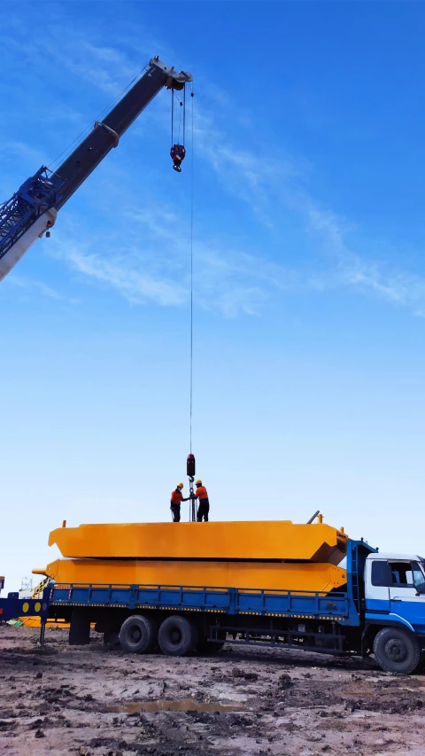 a large crane is being hoisted by two men