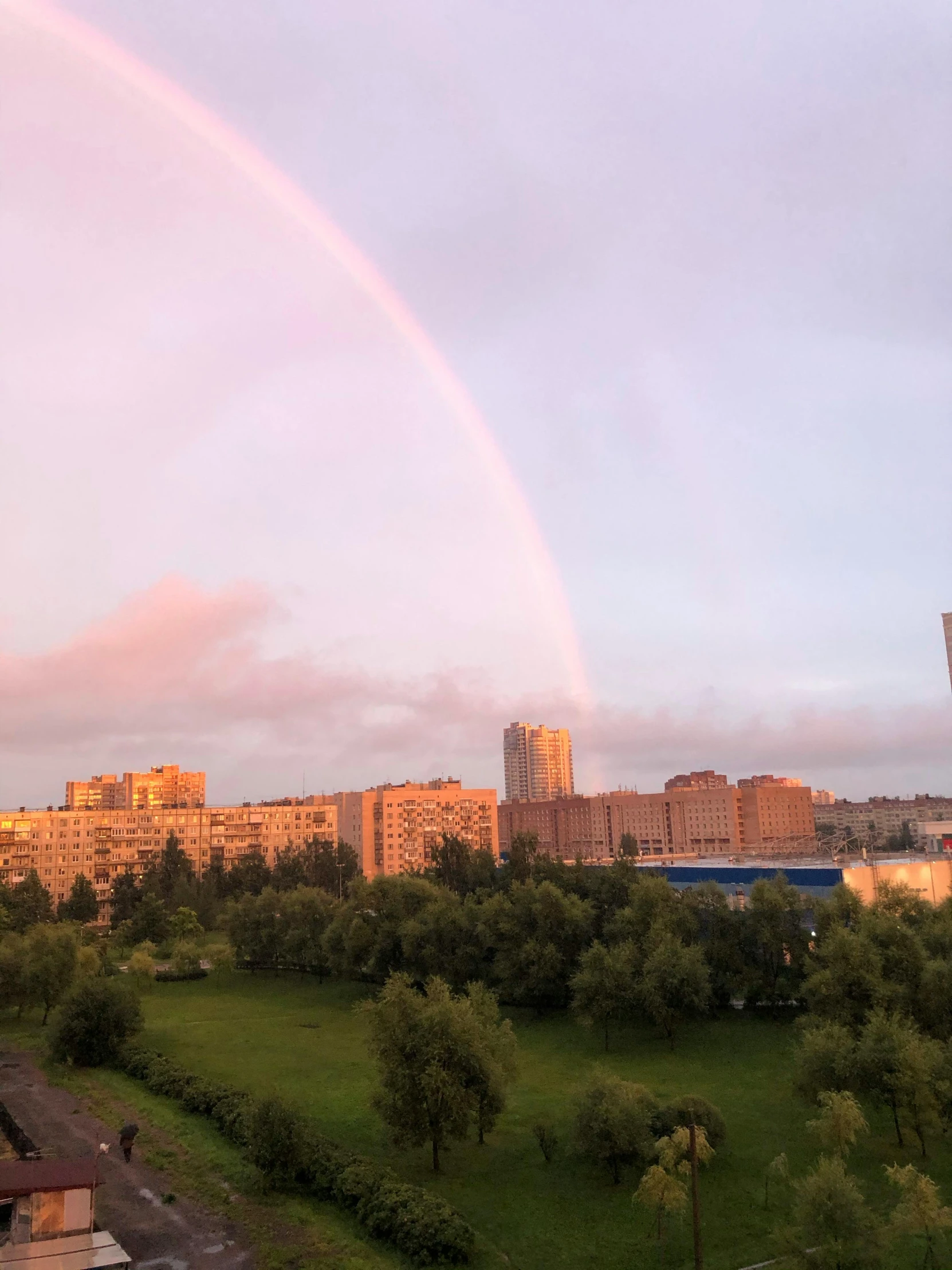 a rainbow is in the sky over a city