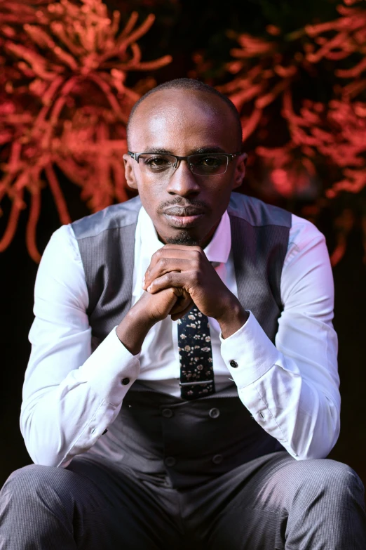 a man in suit and tie looking at soing while sitting