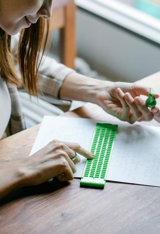 a woman working with a green marker on paper