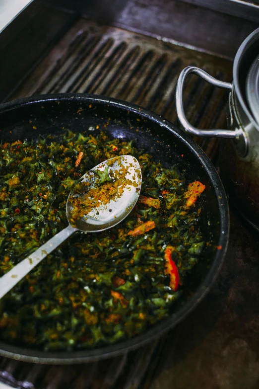 an spoon in some food in a large pan