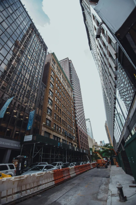 view from ground level of skyscrs and cars in a street