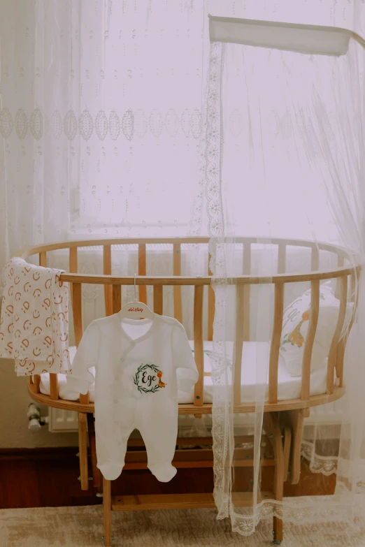 a small white crib with some white clothes and white curtains