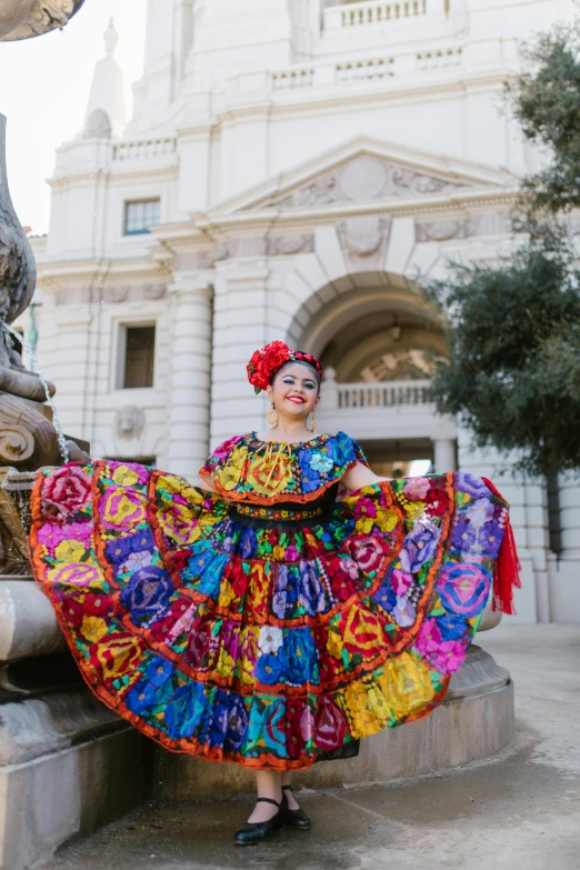 the woman is wearing colorful clothing near the fountain