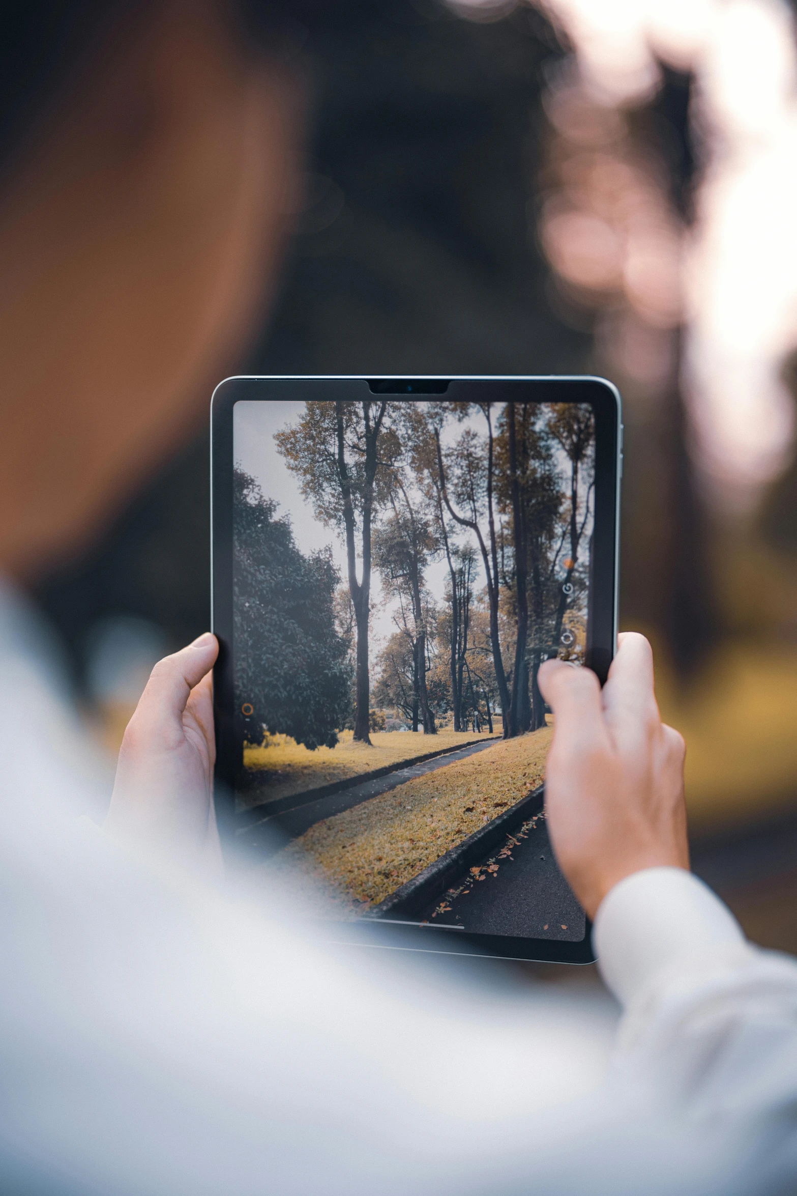 someone holding up a po of an asphalt road