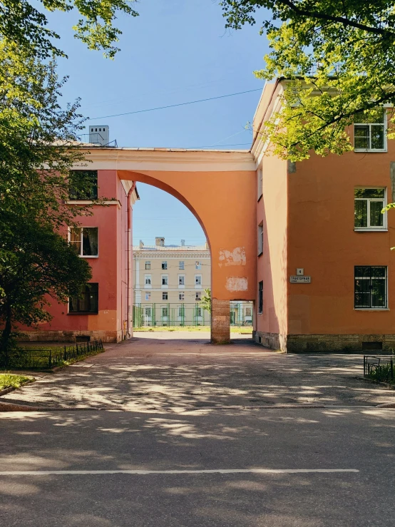 a road with a walkway going under a large arch